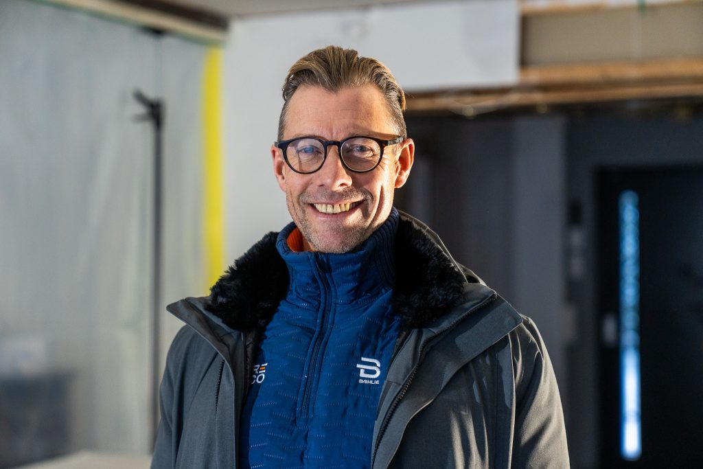En mann med briller og vinterjakke , daglig leder i RECO, Tore Kyvik, smiler innendørs.