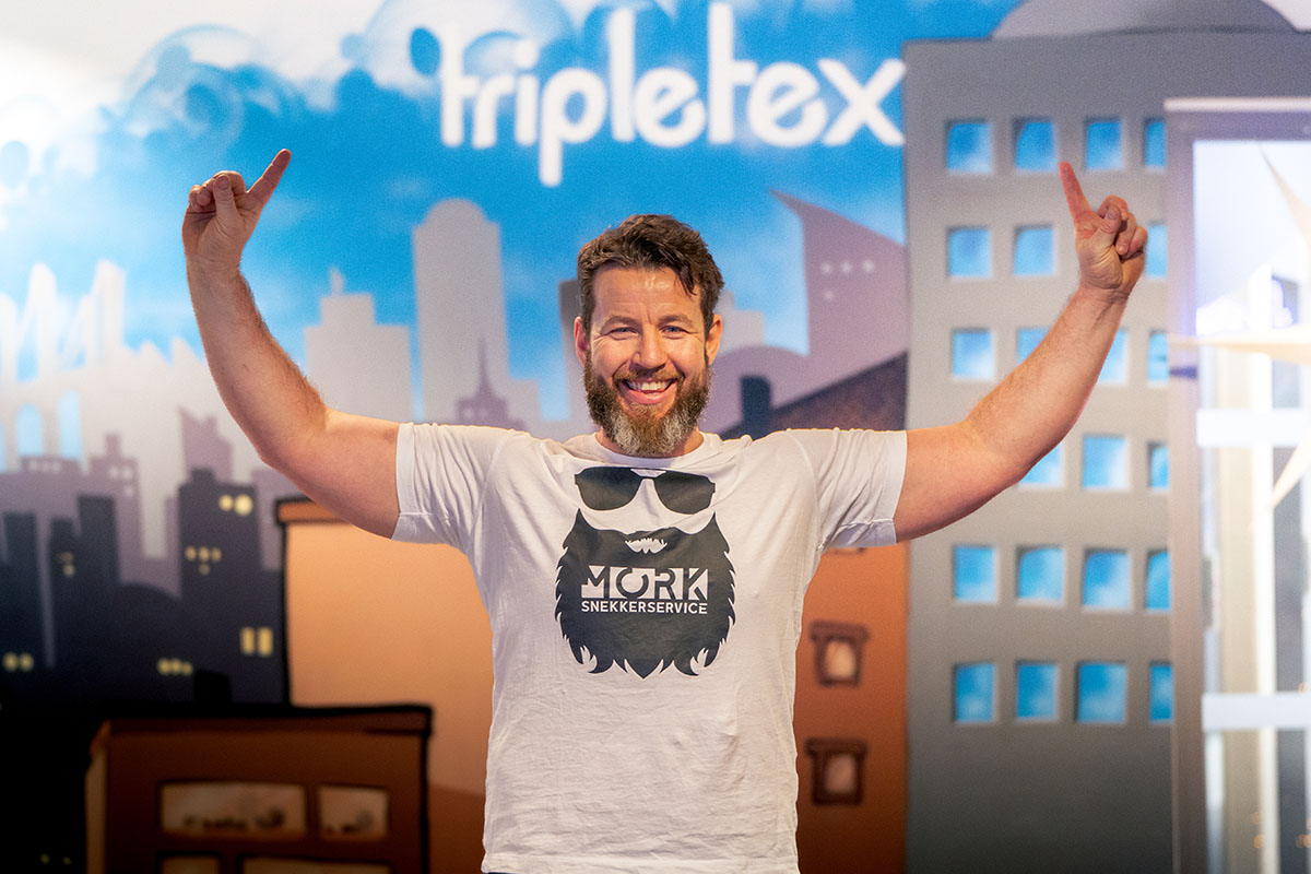 Daniel Mork fra Mork snekkerservice poserer foran en vegg hos Tripletex.