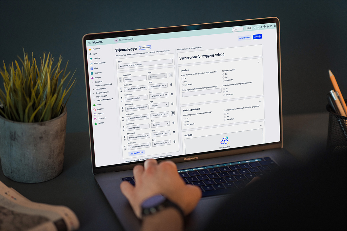 En laptop viser frem et skjemabygger i Tripletex. Ved siden av står en potteplante og en penneholder.