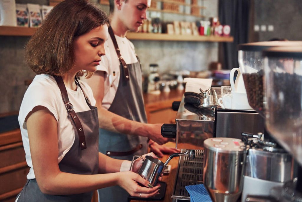 To ungdommer lager kaffe i en kaffebar. Illustrasjonsbilde til sak om sommerjobb for ungdom.