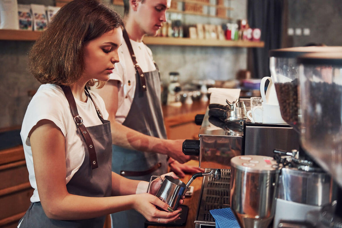 To ungdommer lager kaffe i en kaffebar. Illustrasjonsbilde til sak om sommerjobb for ungdom.