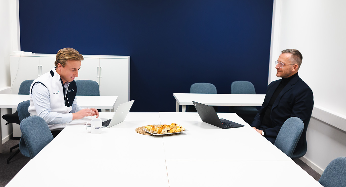 Lise Ekanger er direktør for strategiske kunderelasjoner i Tripletex. En kvinne med blondt hår og briller står smilende i et kontormiljø med pulter, skjermer og mennesker i bakgrunnen.