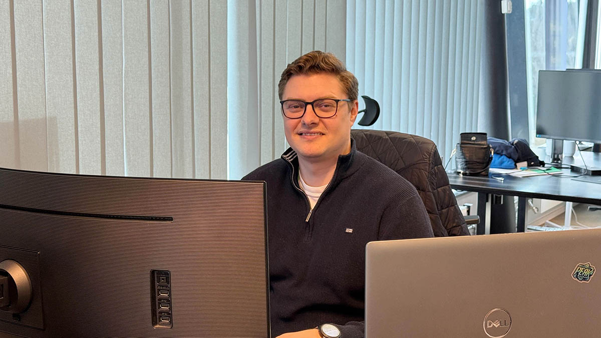 Portrett av Simen Aakre, som sitter bak to PC-skjermer. Til sak om AI-assistenten og riktighet.