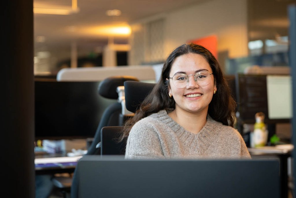 Portrettbilde av UX-designer Thale Meisfjord, sittende bak en dataskjerm.