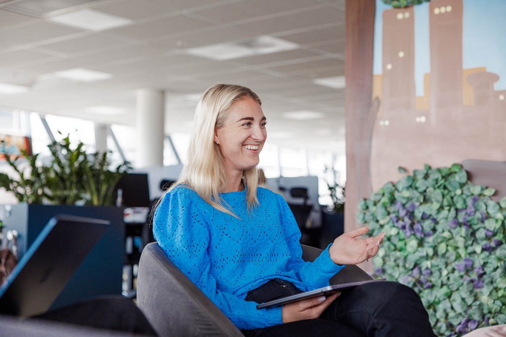 Bilde av Lea Tokerud, kledd i blå genser og sittende i en stol.